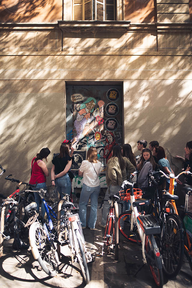 group of students using recycled bikes on a street art tour